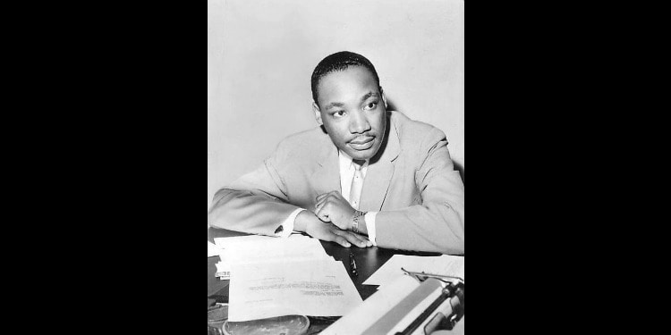 Black and white image of Dr. Martin Luther King looking over some documents.