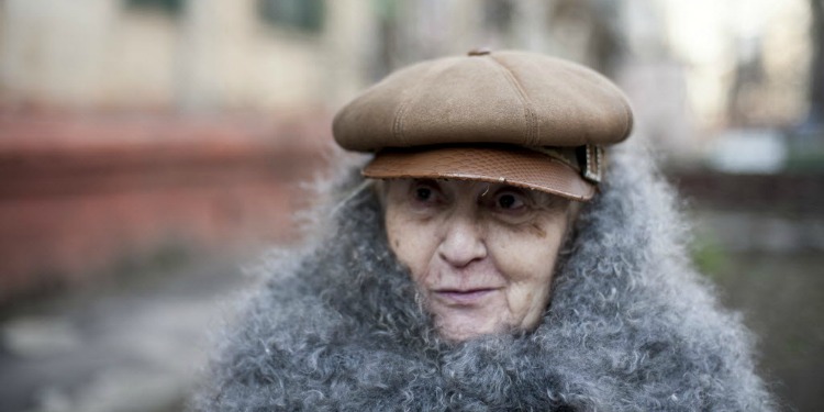 Majina, IFCJ recipient standing outside with a brown hat and furry scarf.
