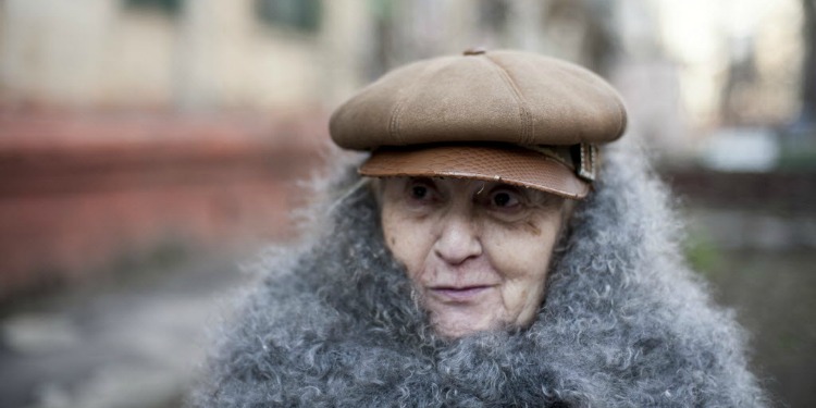 Majina, IFCJ recipient standing outside with a brown hat and furry scarf.