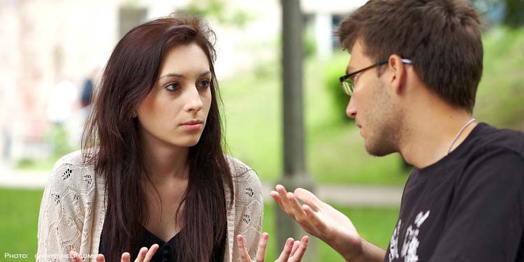 Man and woman looking at each other looking irritated.