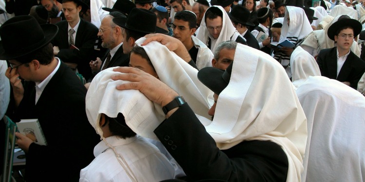 Man with his hands on his sons for priestly blessing.