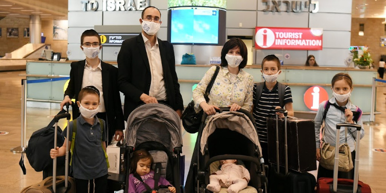 A family of eight with IFCJ masks on in an airport.