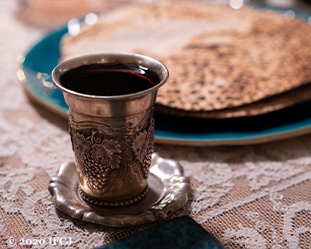 Passover wine in cup with matzah on a plate.