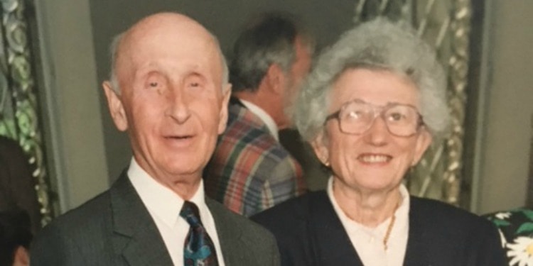 Dated image of an older couple smiling at the camera.