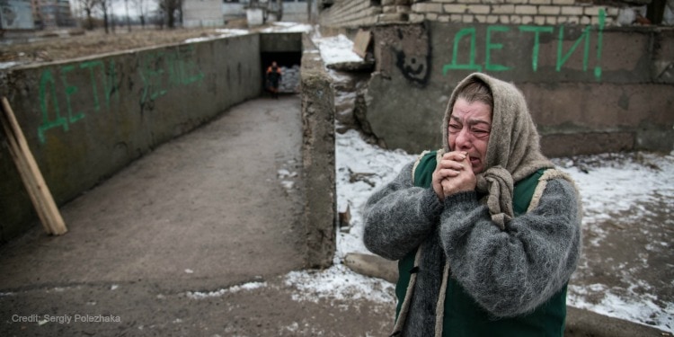 Elderly woman cries with her hands held to her mouth hoping to be saved by your donation