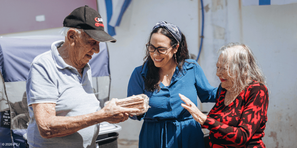 Three people sharing a joyful moment, with an elderly man receiving a gift from a woman, symbolizing compassion and kindness.