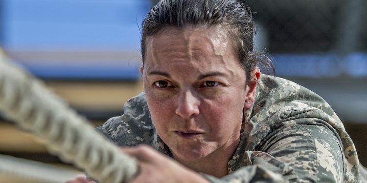 A woman in military uniform holding onto a rope.