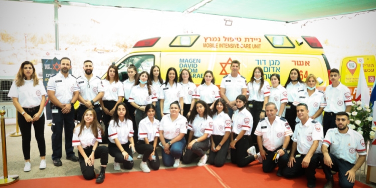 Staff of the mobile ICU smiling in front of the dedicated van.