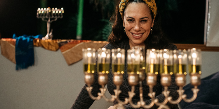 Yael Eckstein smiles with her family's menorah on Hanukkah