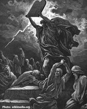Black and white drawing of Moses holding up the Ten Commandments. 