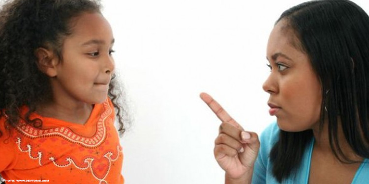 Mother looking at her daughter and scolding her.