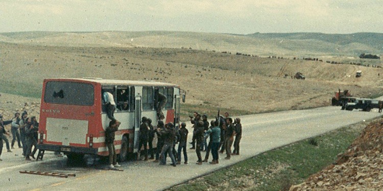 Several people trying to climb into a red and white bus.