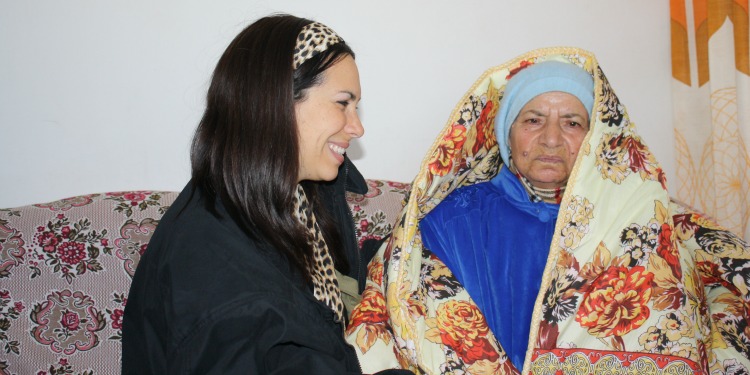 Yael Eckstein smiling at an elderly Jewish woman she's sitting with.