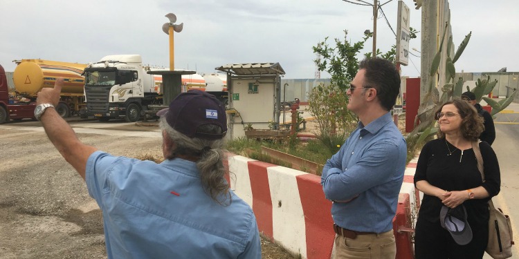 Three people discussing on a construction site.