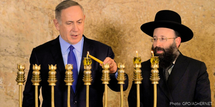 Prime Minister Benjamin Netanyahu accompanied by the Rabbi Shmuel Rabinovitch (Rabbi of the Kotel), lighting the second Hanukkah candle at the Western Wall.