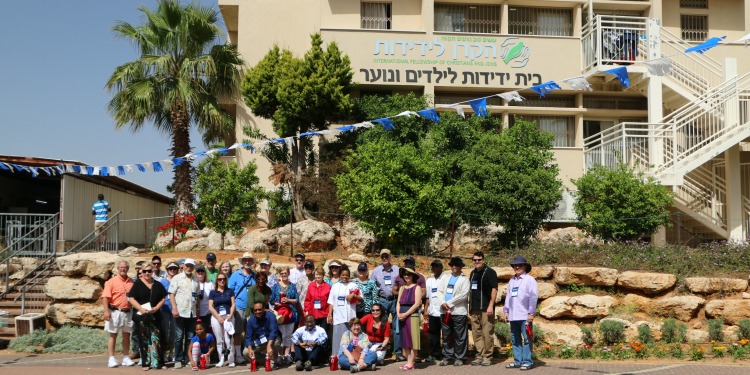 Several people outside of an IFCJ branded building.