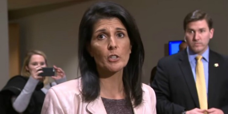 Nikki Haley giving an address while two people are behind her.