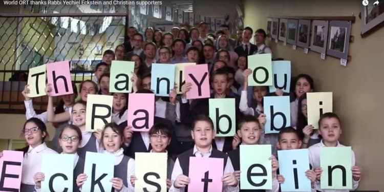 Large group of children holding up a Thank You Rabbi Eckstein sign.