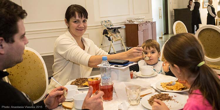 Olim family eating dinner around round table