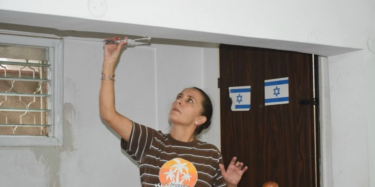 Woman renovating a home with Israeli flags in the background.