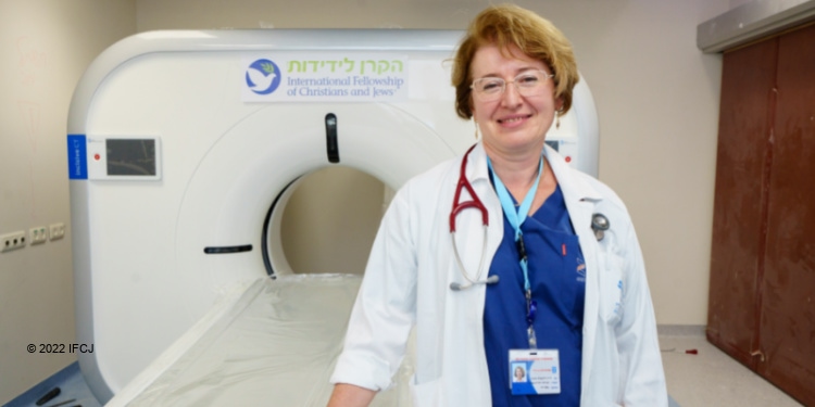 Doctor in front of an MRI scanner with the IFCJ logo on it.