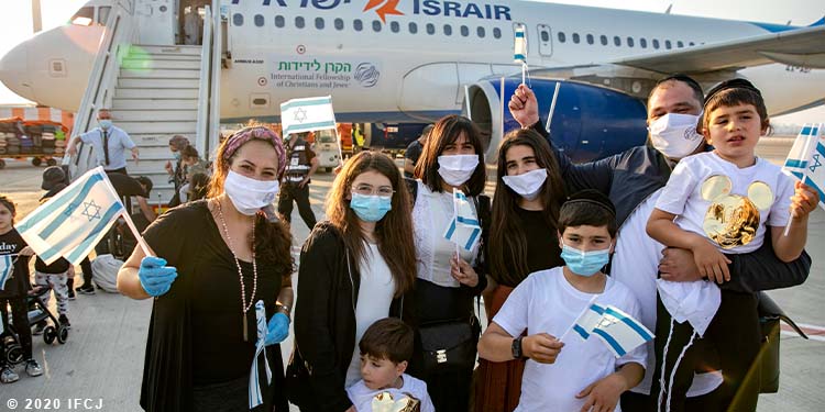 Yael Eckstein standing with a Jewish family who just made aliyah.