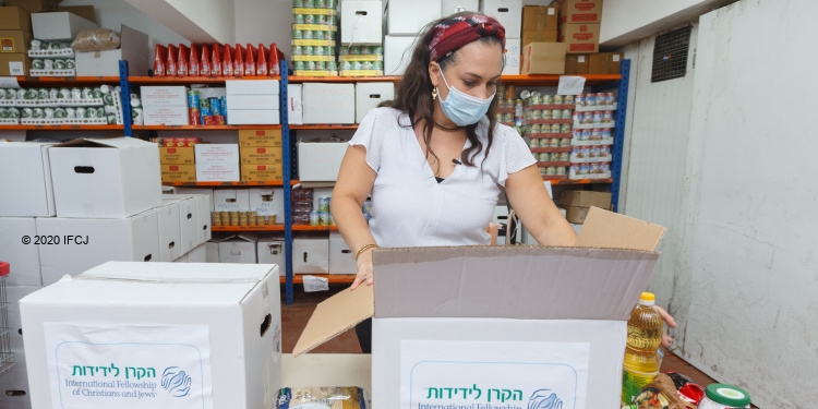 Yael Eckstein packing IFCJ food boxes in a pantry.