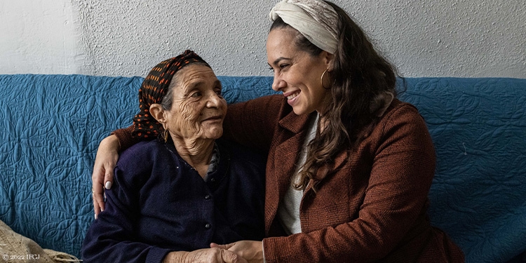 Yael sitting with elderly woman