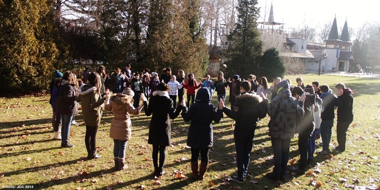 People standing in a prayer circle outside.