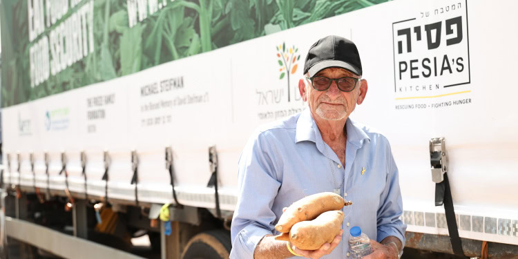 Gideon Ben Ami, founder of Pesia’s Kitchen, holding up sweet potatoes.