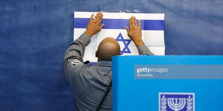 Israeli official hangs flag at polling place