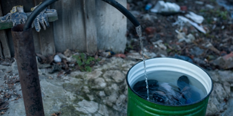 Green bucket, water pump, gloves, pouring water.