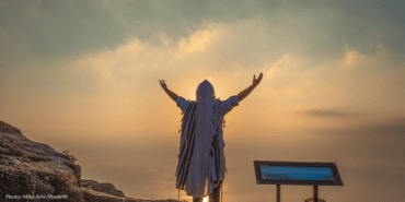 Jewish men wear prayer shawls pray at sunset above the Kinneret, the Sea of Galilee