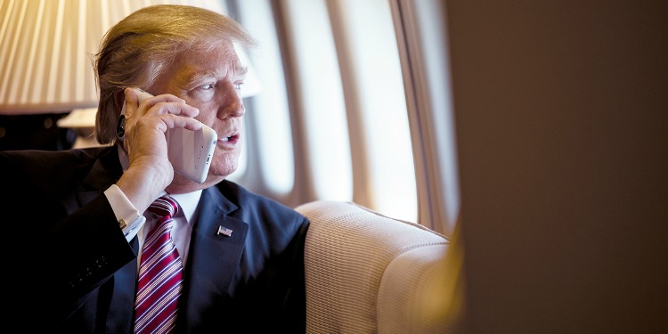 President Trump on a private plane talking on a cell phone.