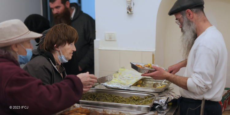 Several in line for a hot meal at an IFCJ sponsored soup kitchen.