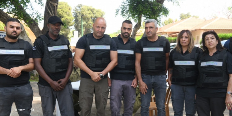 Seven people lined up in protective vests looking directly at the camera.