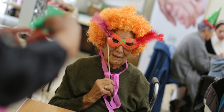 Elderly woman in a wheelchair dressed for Purim.