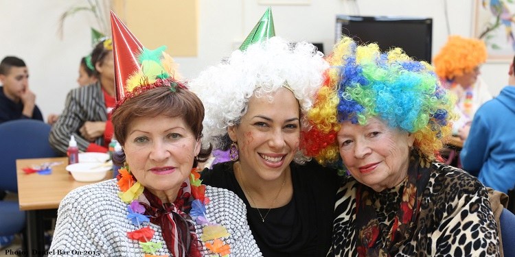 Yael joyously celebrates Purim with two colorful party goers