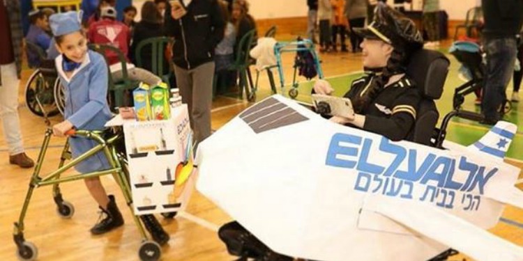 Two young disabled girls dressed up and playing for Purim.