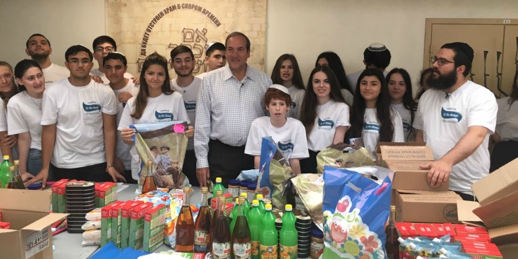 Rabbi Eckstein standing alongside a large group of teens who are volunteering.