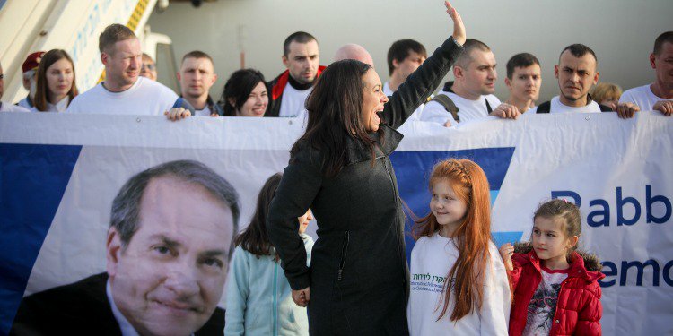 Yael Eckstein excitedly waving at a crowd of supporters at Rabbi Yechiel Eckstein's memorial