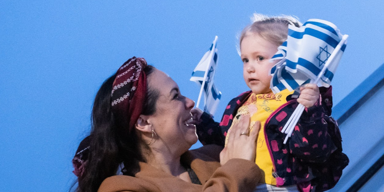Yael Eckstein holds olim chilld who is coming home to Israel on a Fellowship Freedom Flight, February 2020