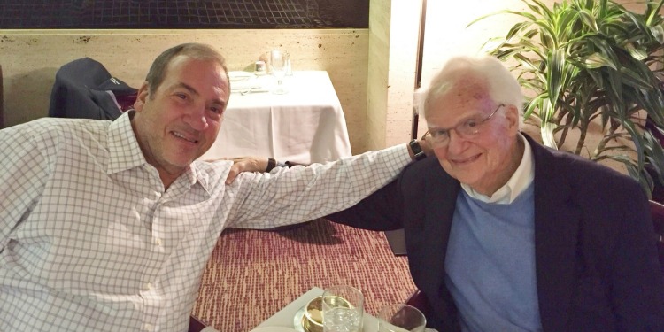 RYE in a white button up seated next to John French.