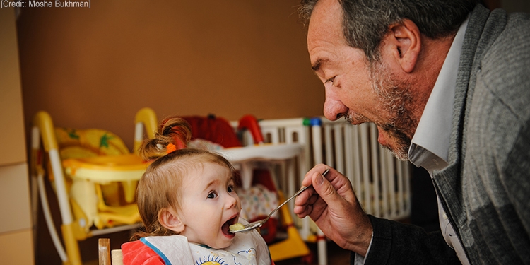 Rabbi Eckstein feeds toddler Sofia