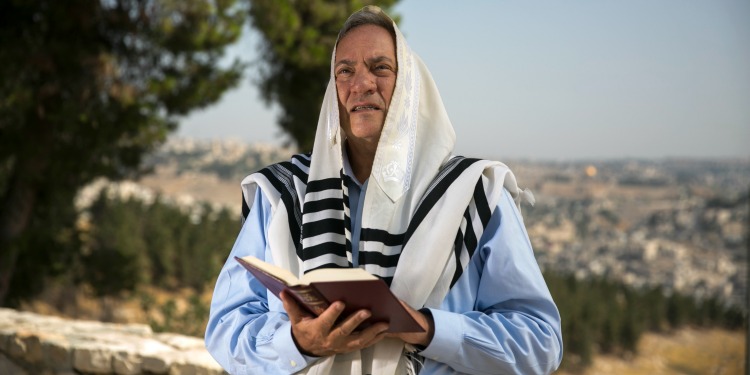 Rabbi Eckstein with a Bible in hand while Jerusalem is in the background.