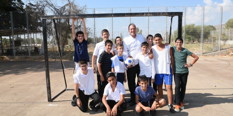 Rabbi Eckstein standing outside with boys from the Kfar Sitrin Home for Boys.