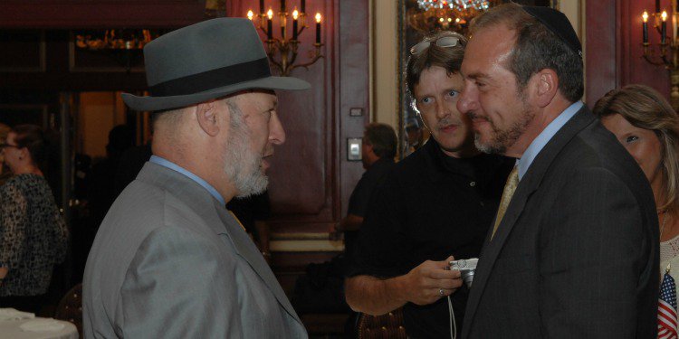 Rabbi Lapin and Rabbi Eckstein talking at a gathering.
