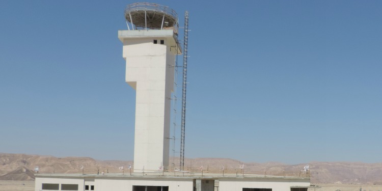 An airport tower in the middle of the desert.
