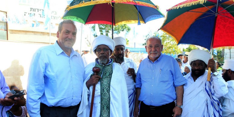 Rabbi Eckstein standing with another man in a blue button down and three Ethiopian Spiritual Leaders.