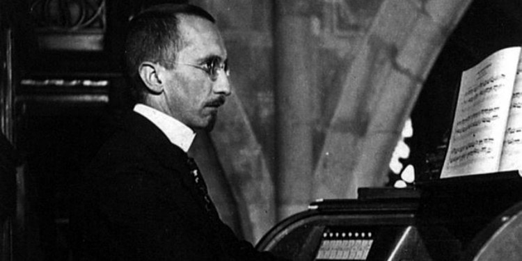 Black and white image of a musician playing piano in church.